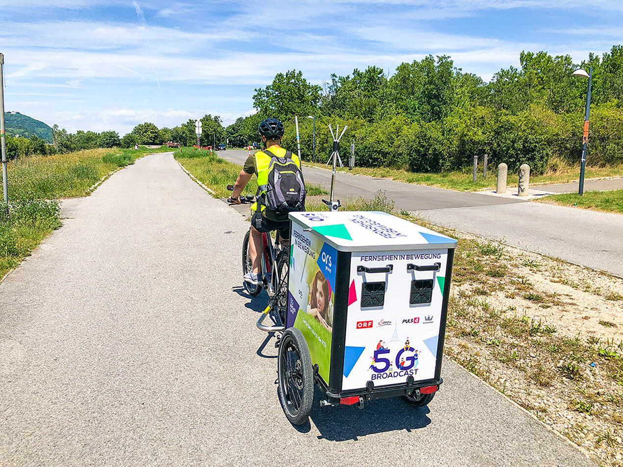 Fahrradfahrer mit Anhänger von hinten