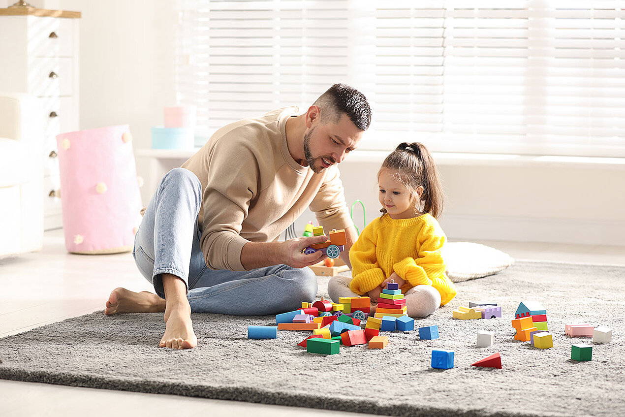 Junger Vater spielt mit kleiner Tochter