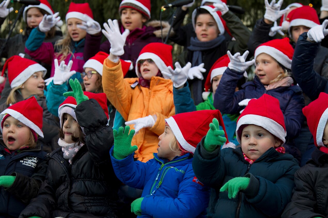 Kinder mit Weihnachtsmützen