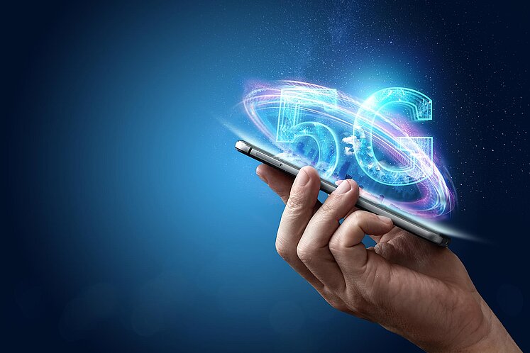 Mann mit Smartphone und 5G Logo