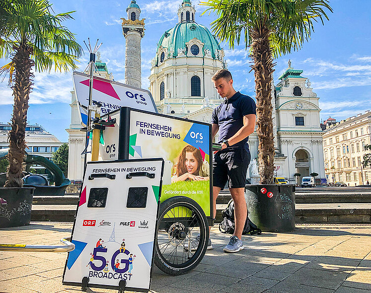 Mann mit Fahrradwagen vor Karlskirche Wien