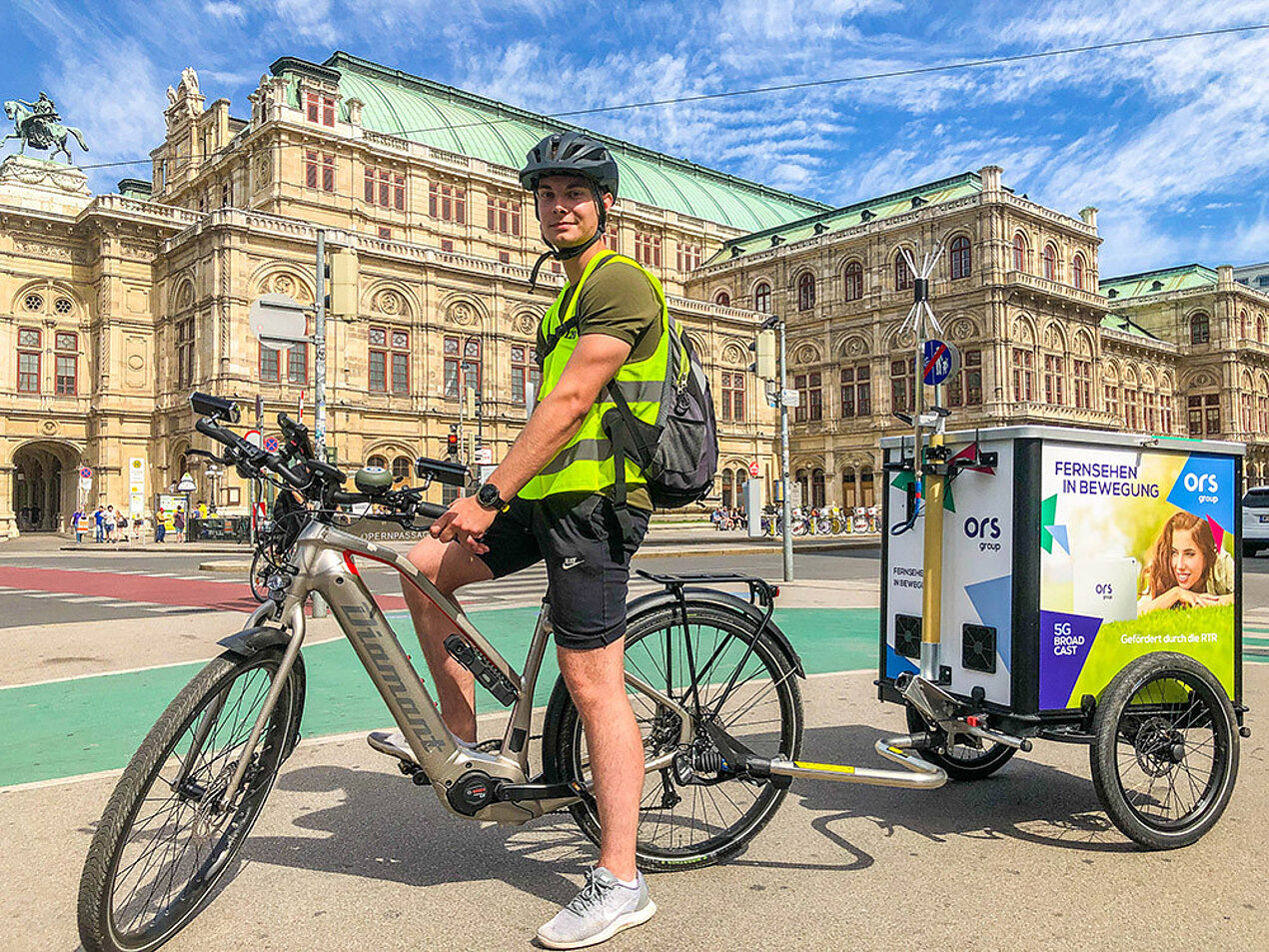 Man with bicycle and trailer in front of State Opera Vienna